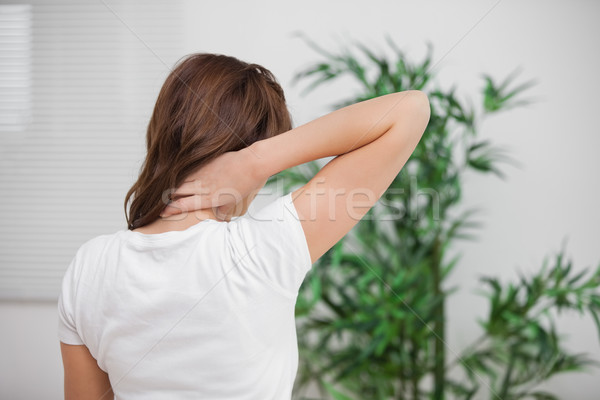 Brunette massaging her painful neck in a room Stock photo © wavebreak_media