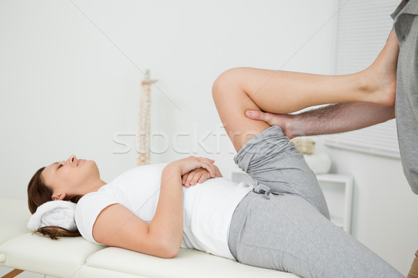 Woman putting her foot on the chest of her doctor while stretching her leg indoors Stock photo © wavebreak_media