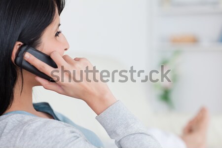 Woman lying on a couch and phoning in a living room Stock photo © wavebreak_media