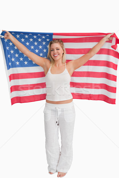 Cheerful blonde woman raising the American flag against a white background Stock photo © wavebreak_media