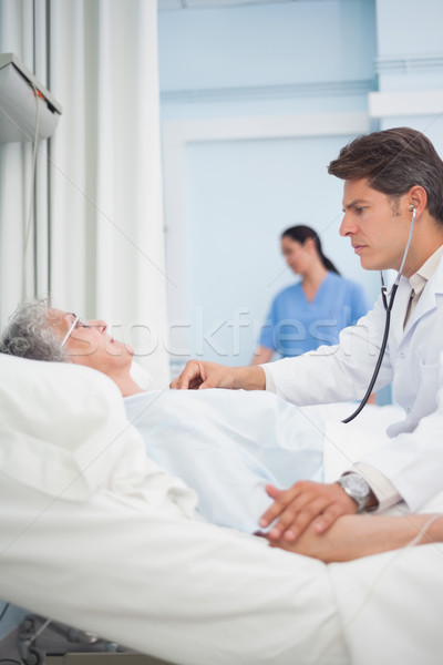 Doctor auscultating a patient with a stethoscope in hospital ward Stock photo © wavebreak_media