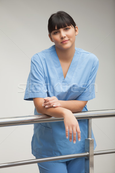 Content nurse leaning against railing in hospital corridor Stock photo © wavebreak_media