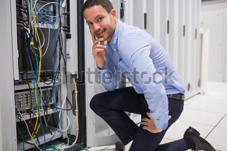 Smiling technician with tablet pc plugging cables into server in data center Stock photo © wavebreak_media