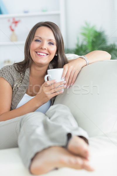 Happy woman drinking a mug on the sofa in the living room  Stock photo © wavebreak_media