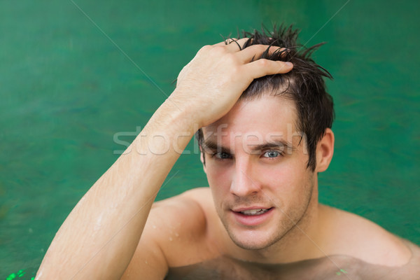 Man touching his hair in the swimming pool Stock photo © wavebreak_media