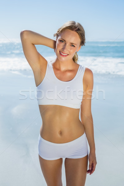 Gorgeous blonde standing by the sea smiling at camera Stock photo © wavebreak_media
