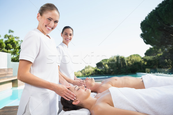 Masseuses smiling at camera while massaging couple Stock photo © wavebreak_media