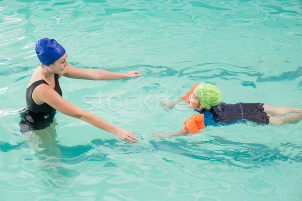 Cute little boy learning to swim with coach Stock photo © wavebreak_media