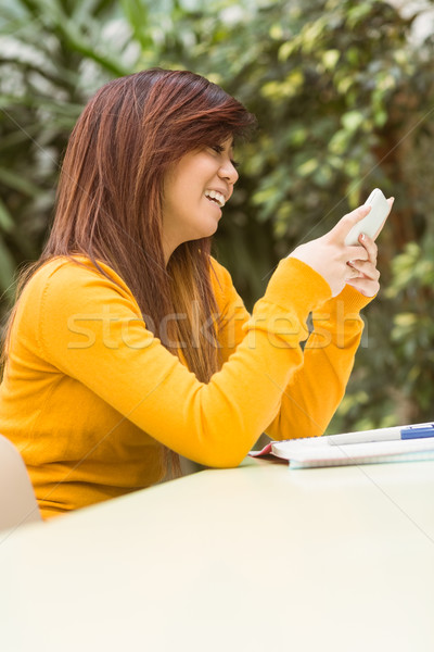 Stock photo: Beautiful female student text messaging