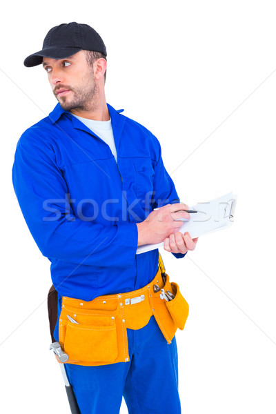 Handyman in blue overall writing on clipboard Stock photo © wavebreak_media