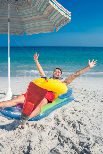 Man lying on the beach with flippers and rubber ring Stock photo © wavebreak_media