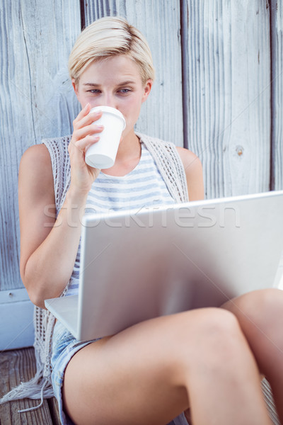 Csinos szőke nő laptopot használ iszik kávé fából készült Stock fotó © wavebreak_media