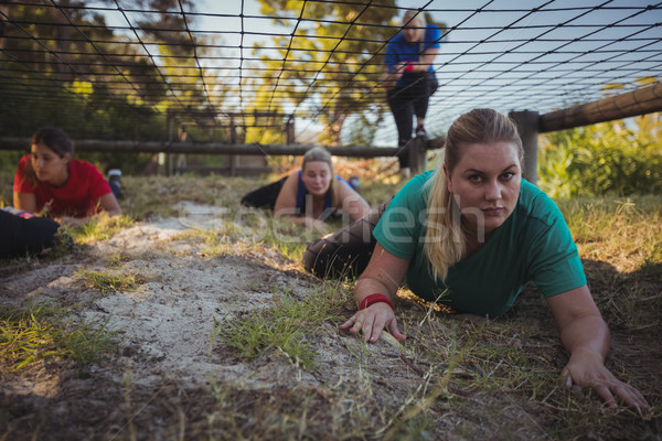 Group of fit women crawling under the net during obstacle course training Stock photo © wavebreak_media