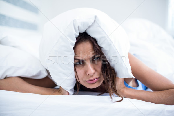 Stock photo: Portrait of irritated woman lying on bed 