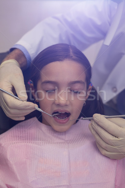Dentist examining a young patient with tools Stock photo © wavebreak_media