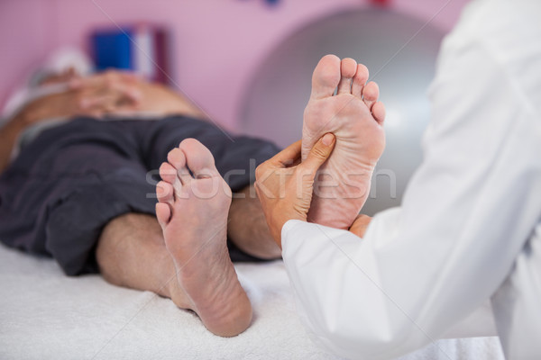 Senior man receiving foot massage from physiotherapist Stock photo © wavebreak_media