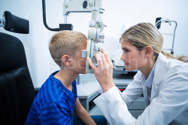 Female optometrist examining young patient on phoropter Stock photo © wavebreak_media