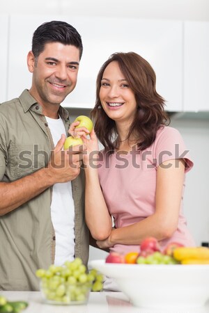 Loving couple eating fruit lying on their bed  Stock photo © wavebreak_media