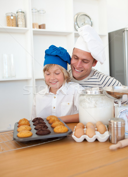 Stock photo: Charming father and his son presenting their muffins