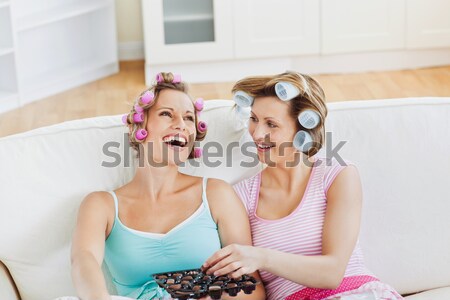 Laughing female friends with hair rollers on a sofa at home Stock photo © wavebreak_media