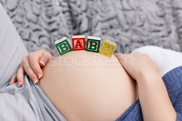 Pregnant young woman with cubes on her belly at home Stock photo © wavebreak_media