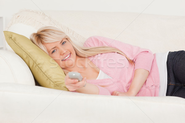 Attractive blonde female posing while lying on a sofa in the living room Stock photo © wavebreak_media