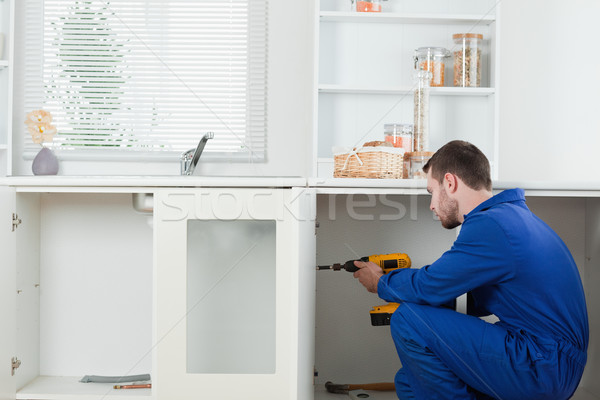 Handsome handyman fixing a door in a kitchen Stock photo © wavebreak_media