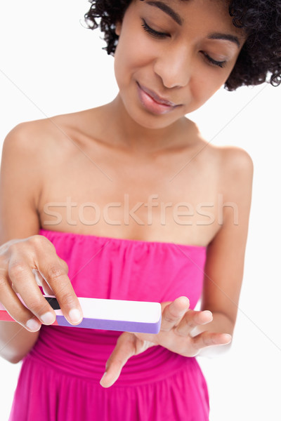 Teenager precisely filing her nails against a white background Stock photo © wavebreak_media