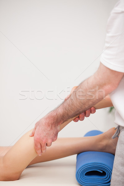 Podiatrist massaging the leg of his patient while standing in a room Stock photo © wavebreak_media
