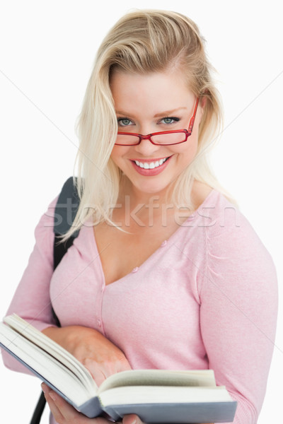 Happy blonde woman looking over her red glasses against a white background Stock photo © wavebreak_media