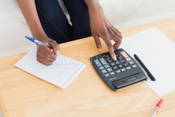 Close up of a woman using a calculator in a living room Stock photo © wavebreak_media