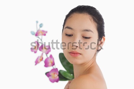 Stock photo: Natural woman looking at a bouquet of orchids