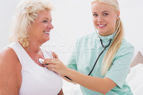 Home nurse examining a smiling aged woman Stock photo © wavebreak_media
