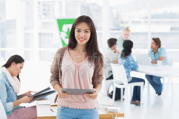 Artist holding digital tablet with colleagues in background at o Stock photo © wavebreak_media