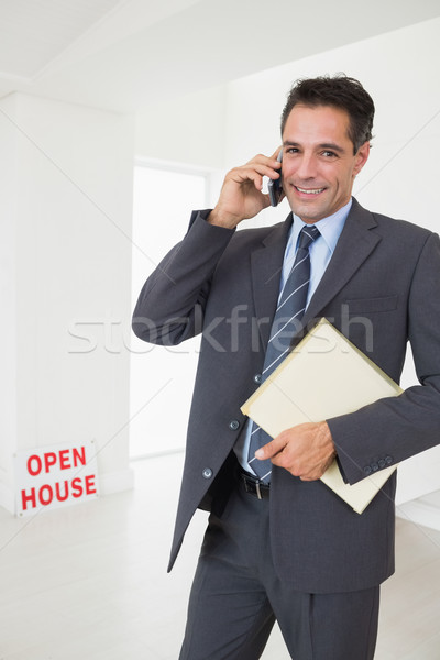 Real estate agent with documents using mobile phone Stock photo © wavebreak_media