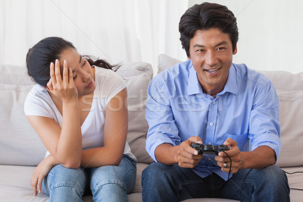 Stock photo: Man ignoring his girlfriend playing video games