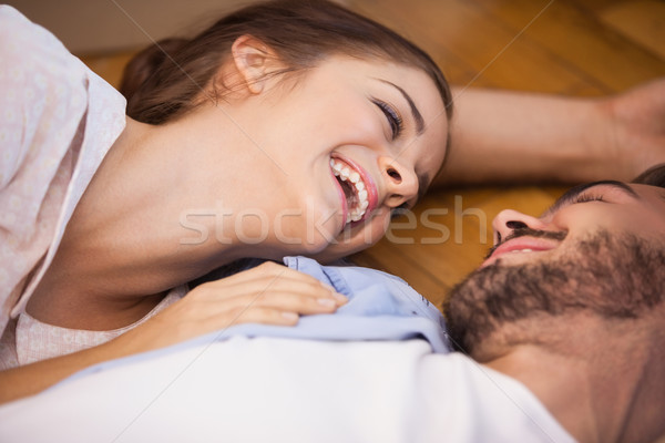 Stock photo: Smiling couple lying on the floor