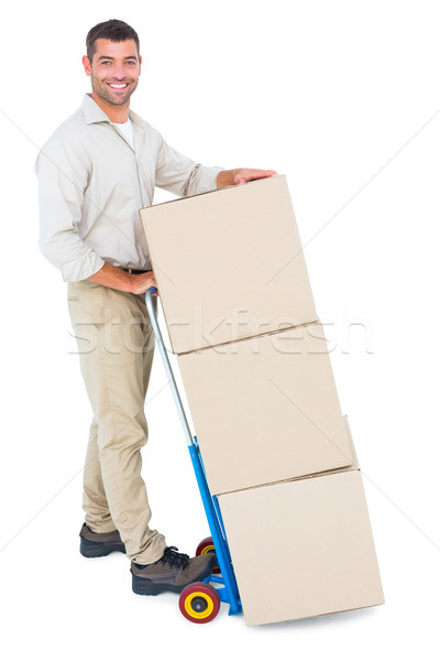 Happy delivery man with trolley of boxes Stock photo © wavebreak_media