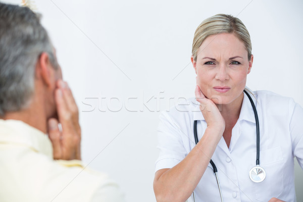 Doctor examining patient with neck ache Stock photo © wavebreak_media