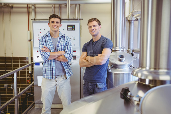 Young men with arms crossed smiling at camera Stock photo © wavebreak_media