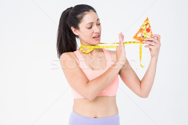 Brunette holding pizza and measuring tape  Stock photo © wavebreak_media