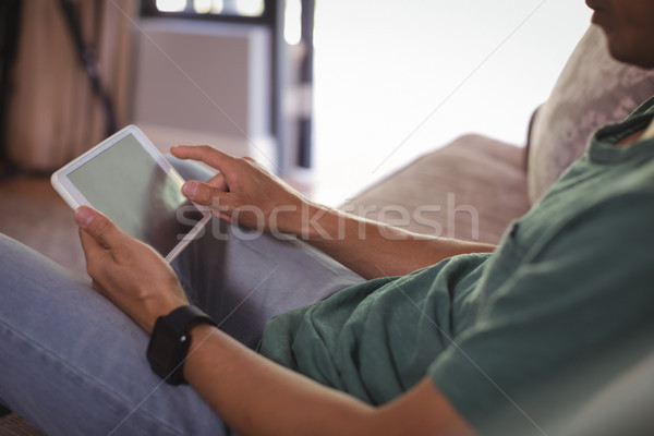 Man using digital tablet in living room Stock photo © wavebreak_media