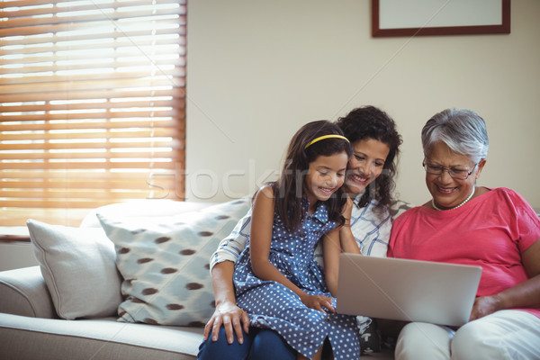 Famille heureuse utilisant un ordinateur portable salon maison internet heureux [[stock_photo]] © wavebreak_media