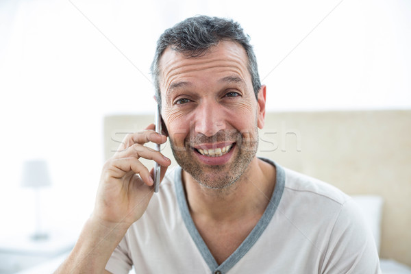 Man talking on smartphone in bedroom Stock photo © wavebreak_media