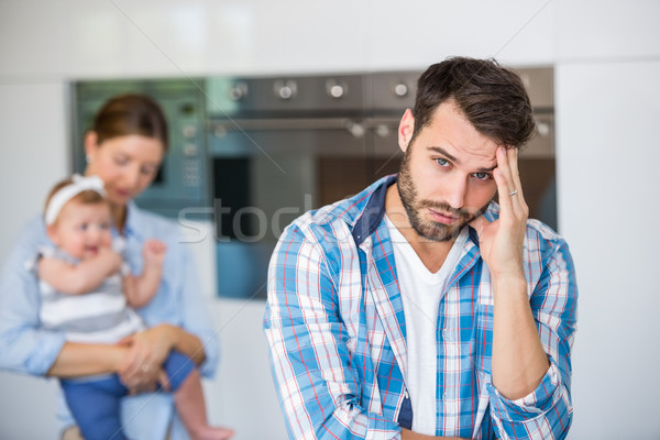 Tensed man with wife and baby in background Stock photo © wavebreak_media