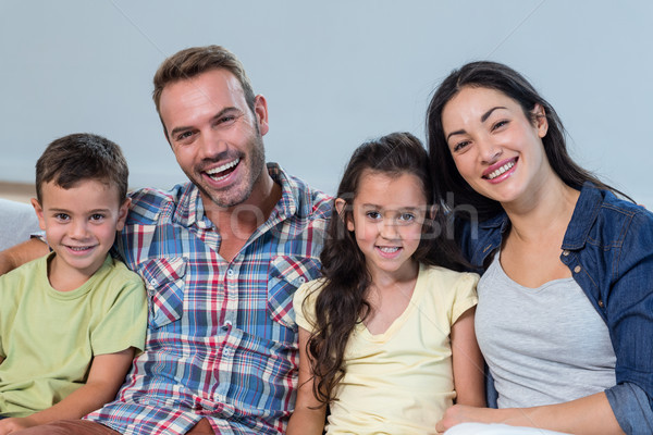 Family sitting on sofa and smiling Stock photo © wavebreak_media