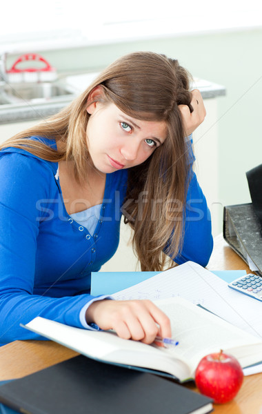 Frustated woman with books sitting at a desk Stock photo © wavebreak_media