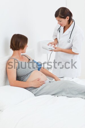Pregnant woman with a nurse on the bed Stock photo © wavebreak_media