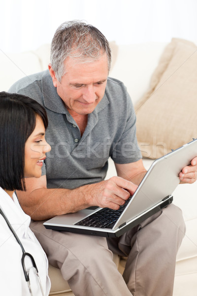 Olgun adam hemşire bakıyor dizüstü bilgisayar ev kadın Stok fotoğraf © wavebreak_media