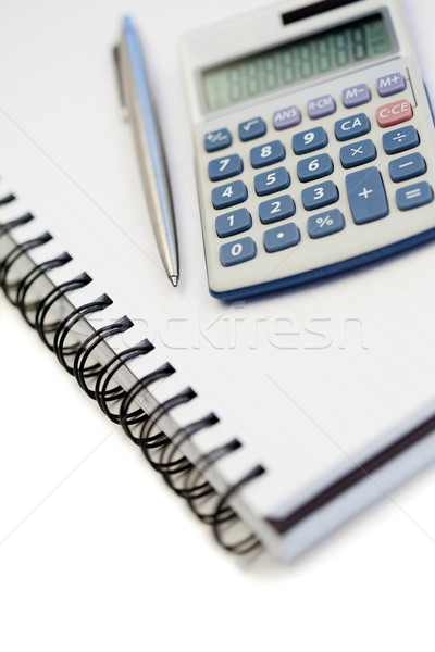 Angled notebook with pencil and pocket calculator on a white background Stock photo © wavebreak_media